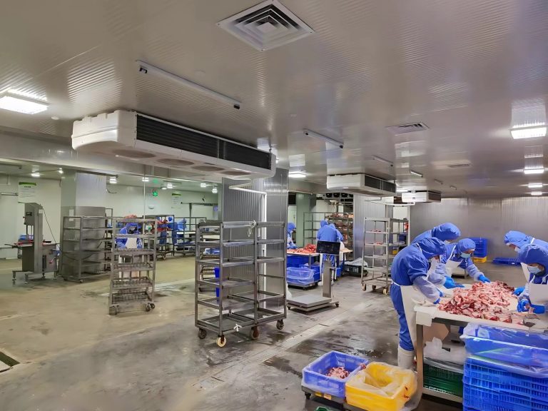 workers processing meat inside a refrigerated food facility